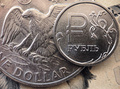 ロシアの首都モスクワで撮影されたロシアの通貨ルーブル硬貨（右）と1米ドル硬貨（2022年3月15日撮影、資料写真）。(c)AFP