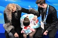 北京冬季五輪、フィギュアスケート女子シングル・フリースケーティング（FS）。キスアンドクライで涙するロシア五輪委員会（ROC）のカミラ・ワリエワ（中央）を慰めるコーチのエテリ・トゥトベリーゼ氏（左、2022年2月17日撮影）。(c)Manan VATSYAYANA / AFP 