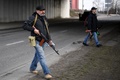 ウクライナの首都キエフで、自動小銃AK47を持ち主要道路を警備する義勇兵（2022年2月25日撮影）。(c)Daniel LEAL / AFP