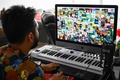 米国人アーティスト、ビープルのデジタルコラージュ作品（画面内）を非代替性トークン（NFT）として6930万ドル（約75億円）で落札したビグネシュ・スンダレサン氏（2021年4月7日撮影）。(c)Roslan RAHMAN / AFP