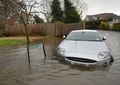 英イングランド（England）南東部バクシャー（Berkshire）州のレイズバリー（Wraysbury）で、冠水した道路に放置された車（2014年2月10日撮影）。(c)AFP/BEN STANSALL