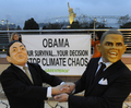 写真は、都内でレインボーブリッジ（Rainbow Bridge）と自由の女神像を背に、バラク・オバマ（Barack Obama）米大統領と鳩山由紀夫（Yukio Hatoyama）首相のマスク姿で、気候変動問題への取り組みを訴えるグリーンピースの活動家（2009年11月13日撮影）。(c)AFP/Kazuhiro NOGI