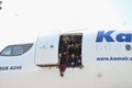 アフガニスタンの首都カブールの空港で、航空機の搭乗口に座り込み待機するアフガン人ら（2021年8月16日撮影）。(c)Wakil Kohsar / AFP