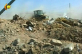 2007年8月15日、地元テレビ局が撮影した自爆攻撃を受けたイラク北部Qataniyah村で、がれきを除去するブルドーザー。(c)AFP/DSK