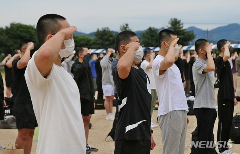 陸軍第37師団で開かれた家族同伴入営式で、敬礼する若者たち(c)NEWSIS