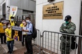 香港の警察署前で、中国の習近平国家主席を暗喩する「くまのプーさん」を描いたプラカードを手にする民主派の活動家ら（2020年5月24日撮影）。(c)AFP/ISAAC LAWRENCE