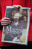 英ロンドン（London）の故マーガレット・サッチャー（Margaret Thatcher）元首相の住居前で、新聞のサッチャー氏を追悼紙面を見せる記者（2013年4月9日撮影）。(c)AFP/CARL COURT