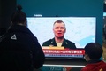 中国・浙江省のショッピングモールで、ウクライナ情勢に関するニュースを見る人（2022年2月25日撮影）。(c)AFP