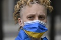 ドイツの首都ベルリンで行われたロシアのウクライナ侵攻に反対するデモで、ウクライナの旗の色をしたマスクを着用した参加者（2022年5月4日撮影、資料写真）。(c)Tobias SCHWARZ / AFP