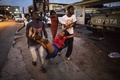 衝突で気を失った後、病院に搬送される拘束男性の親戚。(c)AFP/MARCO LONGARI
