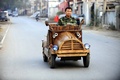 手作りの木製電気自動車で中国北東部の遼寧（Liaoning）省瀋陽（Shenyang）の道路を走る大工の劉福竜（Liu Fulong）さん（2014年10月29日撮影）。(c)AFP