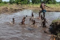 マラウイ南部で、洪水でできた川で泳ぐ少年たち（2019年3月14日撮影）。(c)AMOS GUMULIRA / AFP