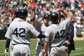 米大リーグ（MLB）で15日、アフリカ系米国人初の大リーガーとして活躍した故ジャッキー・ロビンソン（%%Jackie Robinson%%）氏の栄誉をたたえるジャッキー・ロビンソンデーを迎え、全試合で全選手、全コーチ陣、全審判員が同氏の永久欠番である背番号「42」を着用して試合に臨んだ。写真はオークランド・アスレチックス（%%Oakland Athletics%%）戦で8回に3点本塁打を放ちチームメイトとハイタッチを交わすボストン・レッドソックスのJD・ドリュー（%%J.D. Drew%%、中央）。（2009年4月15日撮影）(c)AFP/Getty Images/Jed Jacobsohn