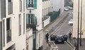 仏パリ（Paris）にある風刺週刊紙シャルリー・エブド（Charlie Hebdo）の本社付近で警察官と対峙する武装した2人の男（2015年1月7日撮影）。(c)AFP/ANNE GELBARD