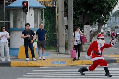 人々を幸せに、自分は健康に 踊るサンタが交通整理 マニラ