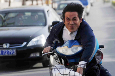 強風と奮闘するバイク乗り、北京