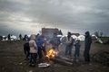 マケドニアの対セルビア国境の村近くにある仮設の移民キャンプで、たき火で体を温める人々（2016年3月9日撮影）。(c)AFP/Robert ATANASOVSKI
