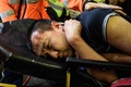 香港空港で、デモ隊から中国のスパイと疑われ負傷した男性を搬送する救急隊員（2019年8月14日撮影）。(c)Anthony WALLACE / AFP