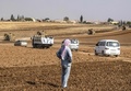 トルコ国境に近いシリア北部の町ダルバシヤ付近でロシア軍と合同パトロールを行うトルコ軍の車両を見る男性（手前、2019年11月1日撮影）。(c)Delil SOULEIMAN / AFP