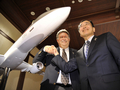 都内の会見で、小型ジェット旅客機「三菱リージョナルジェット（Mitsubishi Regional Jet、MRJ）」100機受注を発表し、笑顔で握手する三菱航空機（Mitsubishi Aircraft）の江川豪雄（Hideo Egawa）社長（右）とトランス・ステーツ・ホールディングス（Trans States Holdings、TSH）のリチャード・リーチ（Richard Leach）社長（2009年10月2日撮影）。(c)AFP/Yoshikazu TSUNO