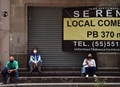 メキシコ・メキシコ市で、シャッターが下ろされた店の前で休む人々（2020年7月31日撮影）。(c)RODRIGO ARANGUA / AFP