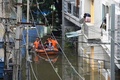 インド・ハイデラバードの豪雨で冠水した通りで、ボートを使って住民を避難させる国家災害対応部隊の隊員ら（2020年10月15日撮影）。(c)NOAH SEELAM / AFP