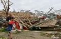 台風14号が上陸した中国・福建省のアモイで、強風で倒れた建物のそばを通る男性（2016年9月15日撮影）。(c)AFP