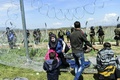 ギリシャ・イドメニの対マケドニア国境で、マケドニア警察と移民や難民が衝突する中、催涙ガス対策として顔面に練り歯磨きを塗り、安全な場所へ逃げる家族（2016年4月10日撮影）。(c)AFP/BULENT KILIC