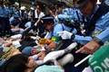 参院平和安全法制特別委員会が横浜市で開いた地方公聴会の会場前で道路に寝転がり、特別委の委員が乗った車の通行を阻止しようとする人たち（2015年9月16日撮影）。(c)AFP/Yoshikazu TSUNO