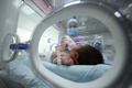 中国・貴州省の病院で、新生児にミルクを飲ませる職員（2021年5月11日撮影）。(c)STR / AFP