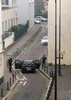 襲撃事件が起きた仏パリ（Paris）の風刺週刊紙シャルリー・エブド（Charlie Hebdo）の本社付近で警察官と対峙する武装した男ら（2015年1月7日撮影）。(c)AFP/ANNE GELBARD