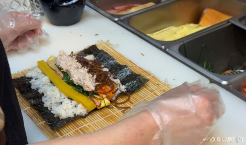 ソウル・恩平区の軽食店で、店主が卵などの具材を使ってキンパを巻いている(c)MONEYTODAY