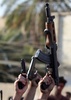イラクで進撃を続けるイスラム武装勢力と戦うイラク治安部隊に、首都バグダッド（Baghdad）で志願し、銃を掲げる人々（2014年6月16日撮影）。(c)AFP/AHMAD AL-RUBAYE