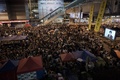 香港（Hong Kong）・金鐘（アドミラルティ、Admiralty）地区で、大画面に映し出された、民主派デモを率いる学生団体の代表と香港政府側の対話の生中継を視聴するデモの参加者ら（2014年10月21日撮影）。(c)AFP/Nicolas ASFOURI