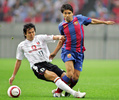 FCバルセロナ（FC Barcelona）との親善試合でデコ（Deco）にスライディングタックルを仕掛ける浦和レッドダイヤモンズ（Urawa Red Diamonds）の長谷部誠（Makoto Hasebe、2005年6月15日撮影）。(c)AFP/Kazuhiro NOGI