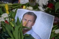 ロシア北極圏の刑務所で獄死した反体制派指導者アレクセイ・ナワリヌイ氏の写真の前に置かれた花。ドイツ・フランクフルトアムマインで（2024年2月20日撮影）。(c) AFP