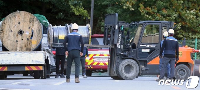 SK C&amp;C板橋キャンパスカカオデータセンターの火災現場で、関係者らがワイヤーロープなど復旧作業のための資材を運んでいる(c)news1