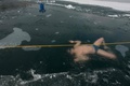 チェコ・テプリツェ近郊のバルボラ湖で、凍結した湖面の下に潜って泳ぐフリーダイバーのデービッド・ベンツルさん。ベンツルさんは、氷の下で長距離を泳ぐギネス世界記録を目指して練習している（2021年2月13日撮影）。(c)Michal Cizek / AFP