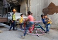 シリアの首都ダマスカス郊外の反体制派支配地区で、遊具で遊ぶ子どもたち（2016年9月13日撮影）。(c)AFP/AMER ALMOHIBANY