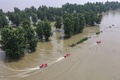 中国東部・江蘇省鎮江で、長江付近の冠水した地区をボートで見回る消防隊員ら（2020年7月20日撮影）。(c)STR / AFP