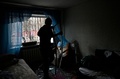 ウクライナの首都キーウで、ロシアのミサイル攻撃で損壊した集合住宅の部屋を片付ける住人（2022年12月31日撮影）。(c)SERGEI CHUZAVKOV / AFP