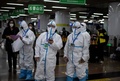 中国・北京西駅で、防護服を着て武漢から到着した旅行者を待つ職員ら（2020年4月15日撮影）。(c)Noel CELIS / AFP