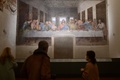 イタリア・ミラノのサンタ・マリア・デッレ・グラツィエ教会内の修道院で、15世紀後半に描かれたレオナルド・ダビンチの作品「最後の晩餐」を鑑賞する人々（2021年2月10日撮影）。(c)MIGUEL MEDINA / AFP