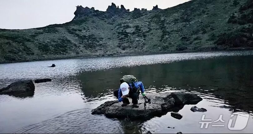立ち入りが禁止されている漢拏山の白鹿潭に入り、水をくんで飲む登山客 (c)news1