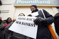 英国のグラフィティ（落書き）アーティスト、バンクシー（Banksy）氏がロンドン（London）市内の壁に描いた絵が、米国で競売にかけられることが分かったが、怒った住民たちの抗議によって競売への出品は中止されたと、地元自治体が24日、明らかにした。

写真は、バンクシー（Banksy）氏の壁画が持ち去られた後の壁にたって抗議する人たち（2013年2月23日撮影）。(c)AFP/JUSTIN TALLIS