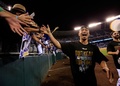 14MLBプレーオフ、ア・リーグ地区シリーズ（5回戦制）、カンザスシティ・ロイヤルズ（Kansas City Royals）対ロサンゼルス・エンゼルス・オブ・アナハイム（Los Angeles Angels of Anaheim）第3戦。試合後、ファンと喜びを分かち合うカンザスシティ・ロイヤルズの青木宣親（Norichika Aoki、2014年10月5日撮影）。(c)AFP/Getty Images/Jamie Squire