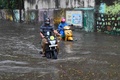 大型サイクロンの豪雨により冠水したインド西部ムンバイの道路をバイクで走る人々（2021年5月17日撮影）。(c)Indranil MUKHERJEE / AFP