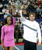 優勝トロフィーを掲げる米国チームのセレーナ・ウィリアムス（左）とマーディー・フィッシュ。(c)AFP/TONY ASHBY
