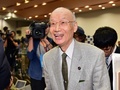 ノーベル医学生理学賞の受賞が決まったことを受けて東京都内の北里大学で開かれた記者会見の会場で、学生らからお祝いの言葉を掛けられて笑顔を見せる大村智・北里大特別栄誉教授（2015年10月5日撮影）。(c)AFP/Yoshikazu TSUNO