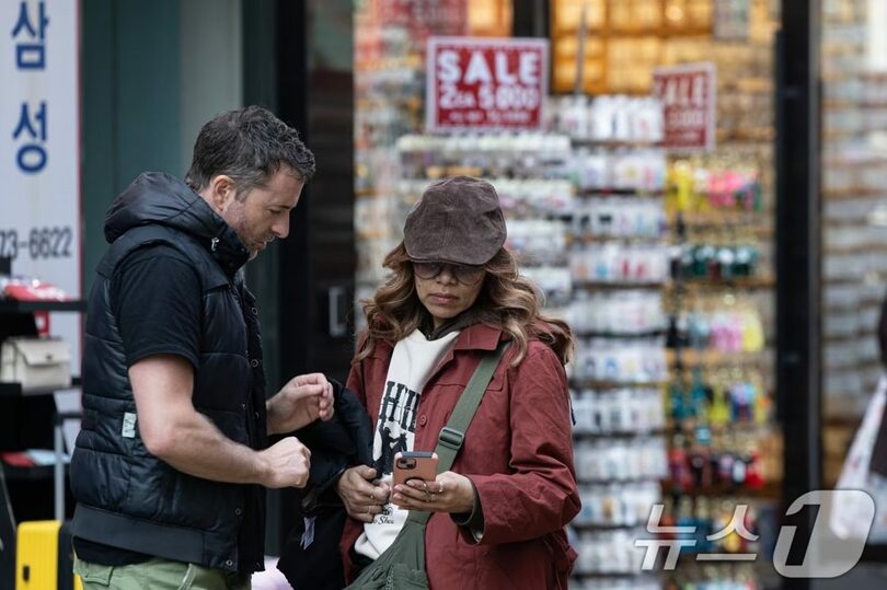 2025年3月10日、ソウル・明洞でスマートフォンを見つめる外国人観光客(c)news1